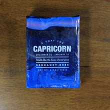 Load image into Gallery viewer, Whiskey Rivers Soap Co. Capricorn Astrology Soap. The bar is dark blue with pink marbled into the top and bottom. In white writing, says "a soap for Capricorn. December 22-January 19. Smells like the boss of everyone. Bergamot Boss."