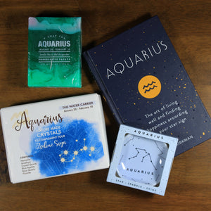 Photo shows the contents of the What's Your Sign Aquarius Gift Box: Aquarius book, Aquarius ring dish, Aquarius crystals, and Aquarius soap. 
