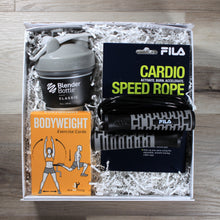 Load image into Gallery viewer, This photo shows an overhead shot of the Reps and Ropes gift box from Doromania, which includes a bottle with a grey lid, a black jump rope with grey handles, and a yellow box of exercise cards, all in a white gift box with white crinkle paper