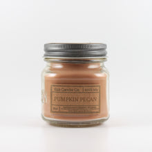 Load image into Gallery viewer, Mason Jar candle: an 8 oz mason jar with a metal cap, filled with brown wax, with a kraft paper label on the front that reads "Pumpkin Pecan"