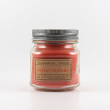 Load image into Gallery viewer, Mason Jar candle: an 8 oz mason jar with a metal cap, filled with red wax, with a kraft paper label on the front that reads "Apple Orchard"