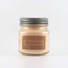 Load image into Gallery viewer, Mason Jar candle: an 8 oz mason jar with a metal cap, filled with off white wax, with a kraft paper label on the front that reads "Wedded Bliss"