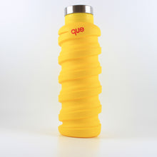Load image into Gallery viewer, A photo of a yellow bottle with a metal cap that says "que" in pink; the bottle has a spiral design.