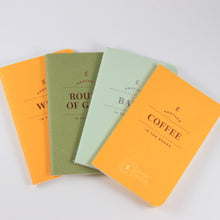 Load image into Gallery viewer, Four small journals fanned across a white background. Journals, from left to right, are yellow, green, mint green, and yellow. The top journal has gold print that says "Another coffee in the books"