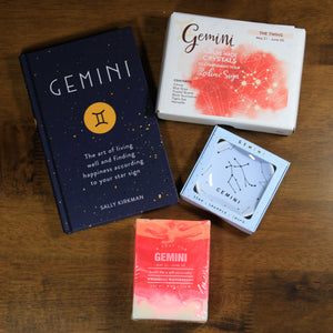 An overhead view of the contents of the "What's your sign" Gemini zodiac gift box which includes a Gemini book, Gemini soap, Gemini crystals, and a Gemini ring dish