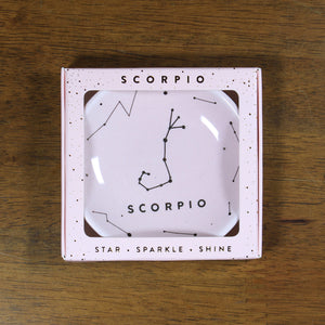 Scorpio Zodiac Ring Dish from Lucky Feather. Blush pink ring dish with gold print. Ring dish says Scorpio and has an illustration of the Scorpio constellation. 