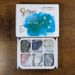 Scorpio Horoscope Crystals from Rock Paradise. Photo shows a white box that has a blue ink blot with the Scorpio constellation and illustrations of gemstones. The box reads "Scorpio nature made crystals to complement your zodiac sign." Box has 6 crystals in it.