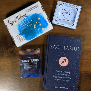 Contents of What's Your Sign Sagittarius gift box: blue Sagittarius horoscope book, box of Sagittarius natural crystals, pink Sagittarius ring dish, and orange and blue Sagittarius soap