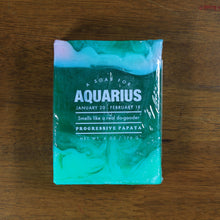 Load image into Gallery viewer, Whiskey Rivers Soap Co. Aquarius Astrology Soap. The bar is a mix of translucent and opaque teal colors. In white writing, says &quot;a soap for Aquarius. January 20-February 18. Smells like a real do-gooder. Progressive Papaya.&quot;