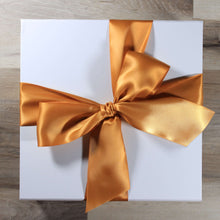 Load image into Gallery viewer, An overhead view of a white magnetic square gift box with a butterscotch satin ribbon tied in a bow