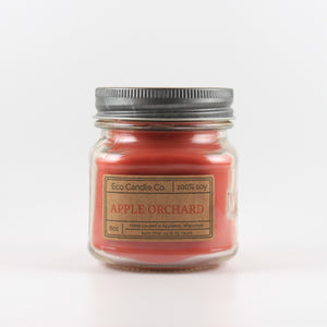 Apple Orchard Mason Jar candle: an 8 oz mason jar with a metal cap, filled with red wax, with a kraft paper label on the front that reads "Apple Orchard"
