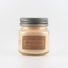 Load image into Gallery viewer, Mason Jar candle: an 8 oz mason jar with a metal cap, filled with off white wax, with a kraft paper label on the front that reads &quot;Wedded Bliss&quot;