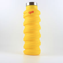 Load image into Gallery viewer, A photo of a yellow bottle with a metal cap that says &quot;que&quot; in pink; the bottle has a spiral design.