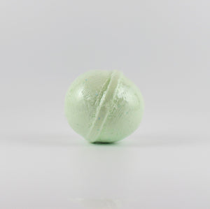 A mint green colored, oval shaped bath bomb on a white background