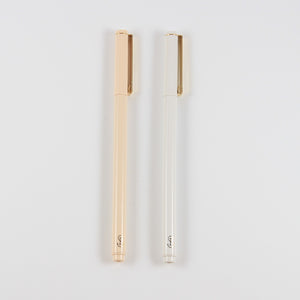 A photo of two pens, one white and one blush pink, side by side. They both have a gold clip on the cap, and a gold "SP" logo at the end.