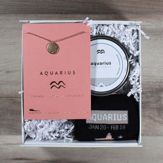 small Aquarius gift box with an aquarius disc necklace, an aquarius candle, and aquarius socks. These gifts are in a white gift box with white crinkle paper