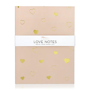 A light pink journal with hearts in solid gold and gold line art. A band around the journal says "Love notes, write your heart out."