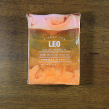 Load image into Gallery viewer, Whiskey Rivers Soap Co. Leo Astrology Soap. The bar is translucent orange with opaque orange on the bottom and pink swirled into the top. In white writing, says &quot;a soap for Leo. July 23-August 22. Smells like it’s all about you. Vanilla Vanity.&quot;