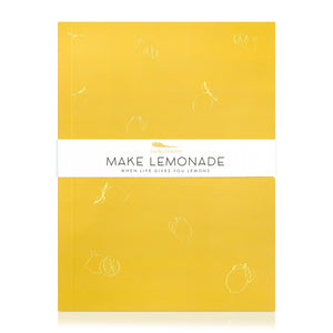 A yellow journal with gold embossed illustrations of lemons. A band around the journal says "Make Lemonade, when life gives you lemons."