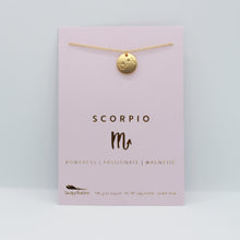 Load image into Gallery viewer, Scorpio zodiac necklace from Lucky Feather. A gold disc necklace with the scorpio constellation engraved on it. The necklace is packaged on a pink necklace display card.